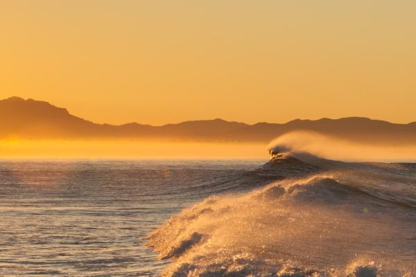 sun rising behind offshore wind blown waves