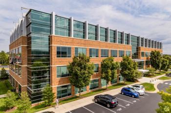 A 4-story brick office building with large glass windows.